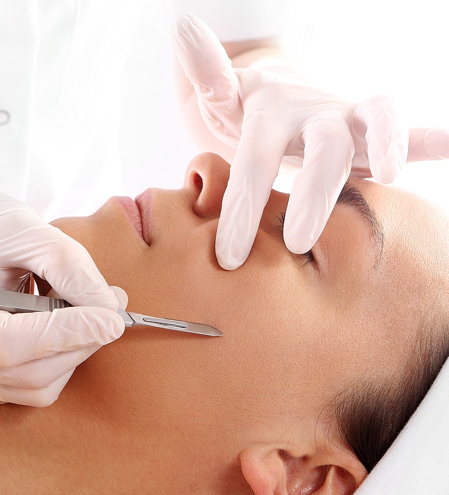 Facial treatment with gentle blade on skin.