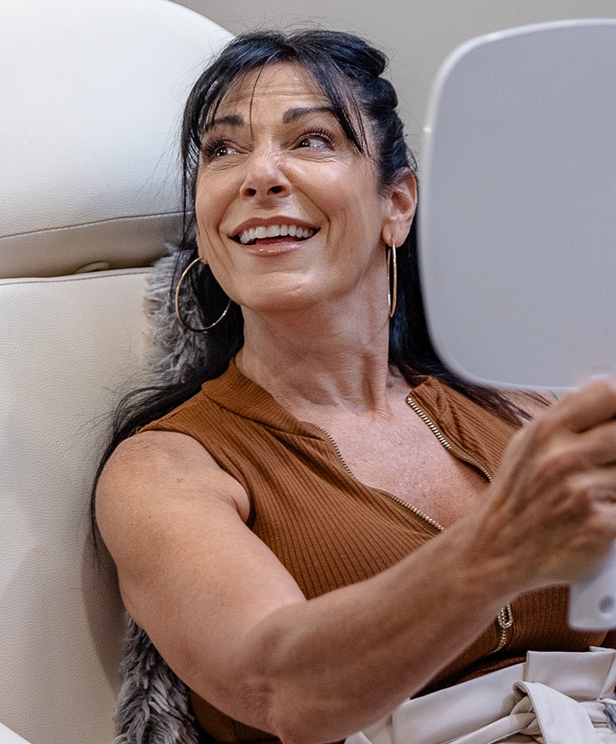 Woman happily admiring herself in mirror.