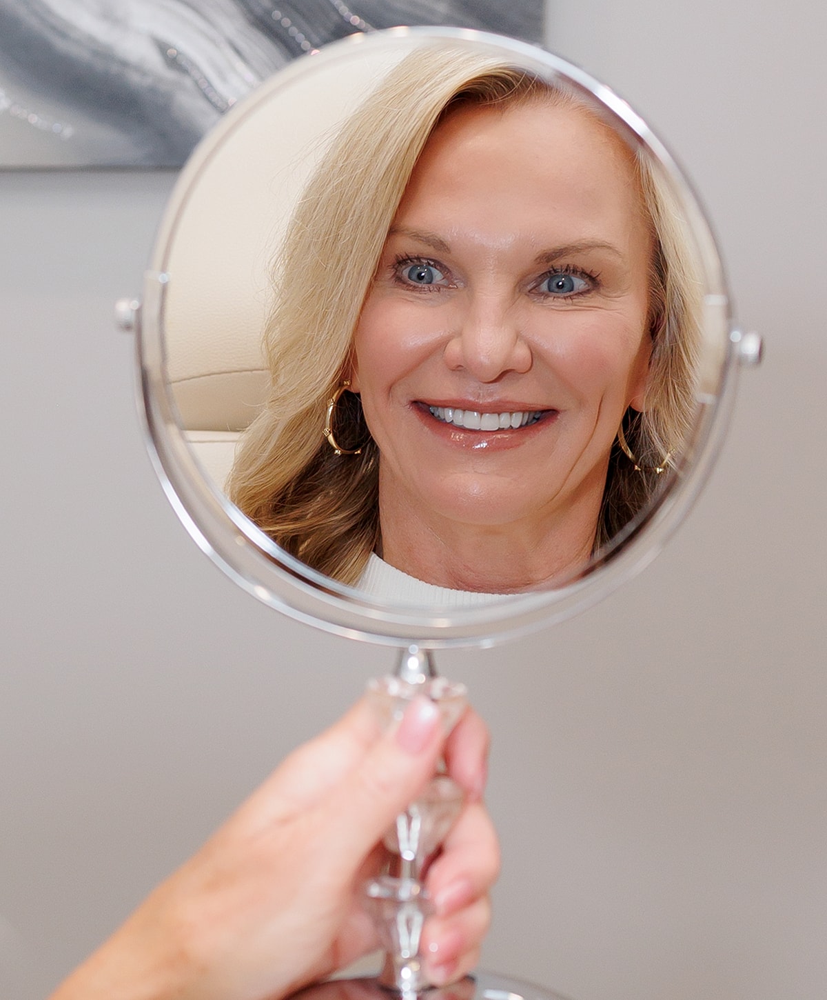 Woman smiling in a mirror reflection.