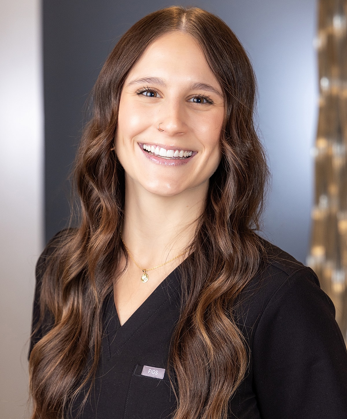 Smiling healthcare professional in scrubs.