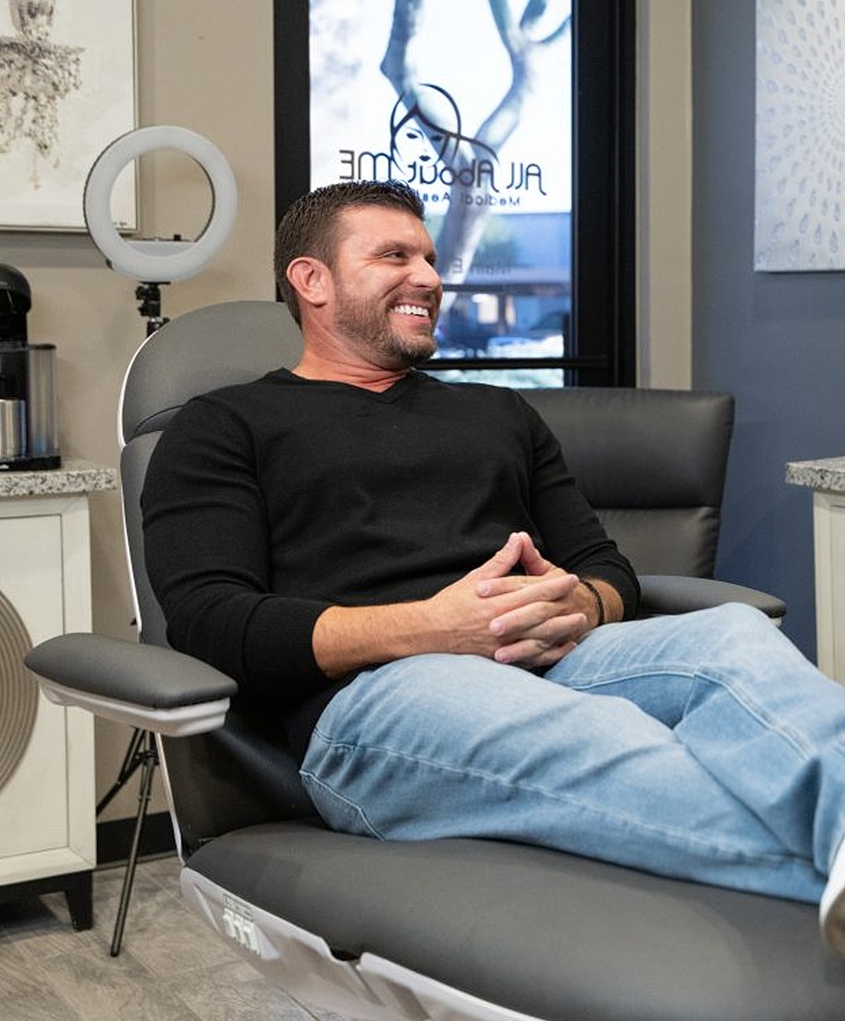 Man smiling while sitting in a modern chair.