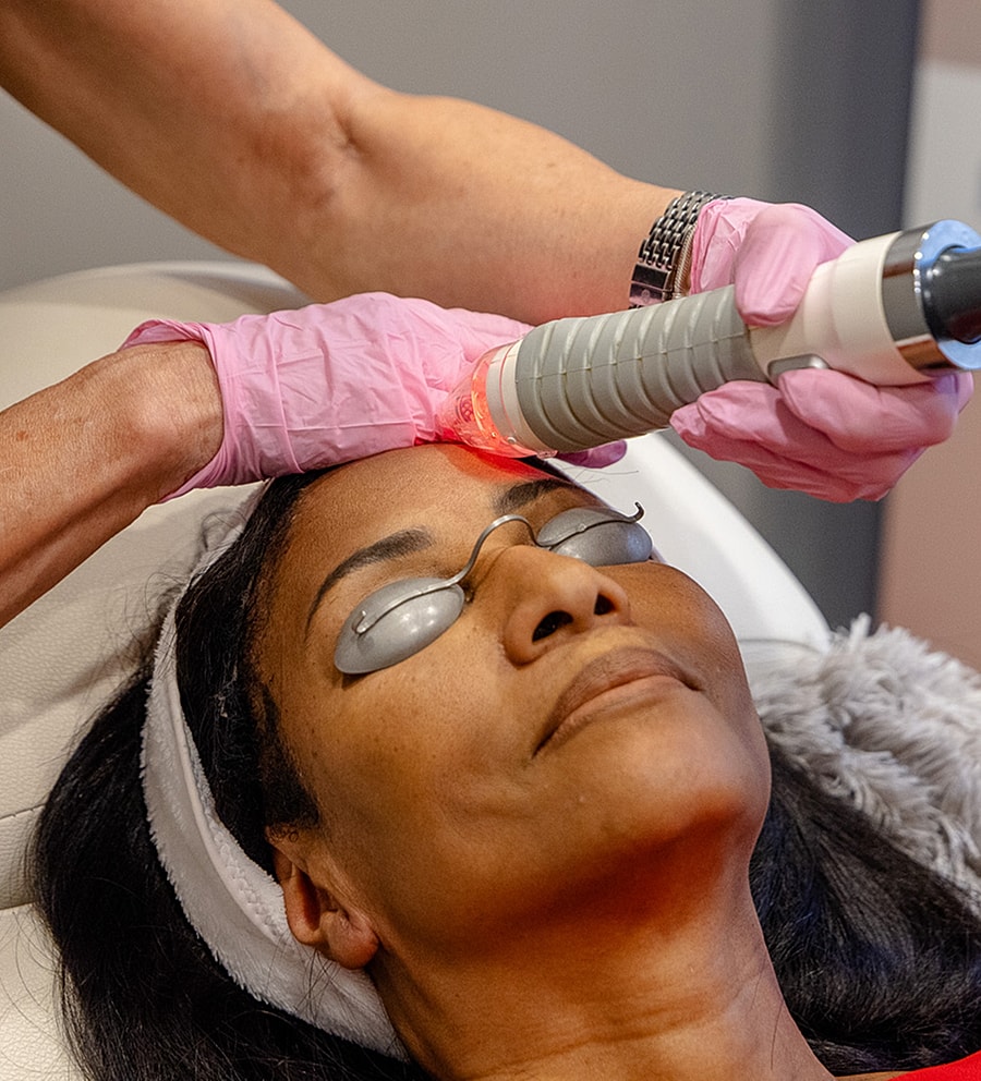 Woman receiving a facial treatment with laser device.