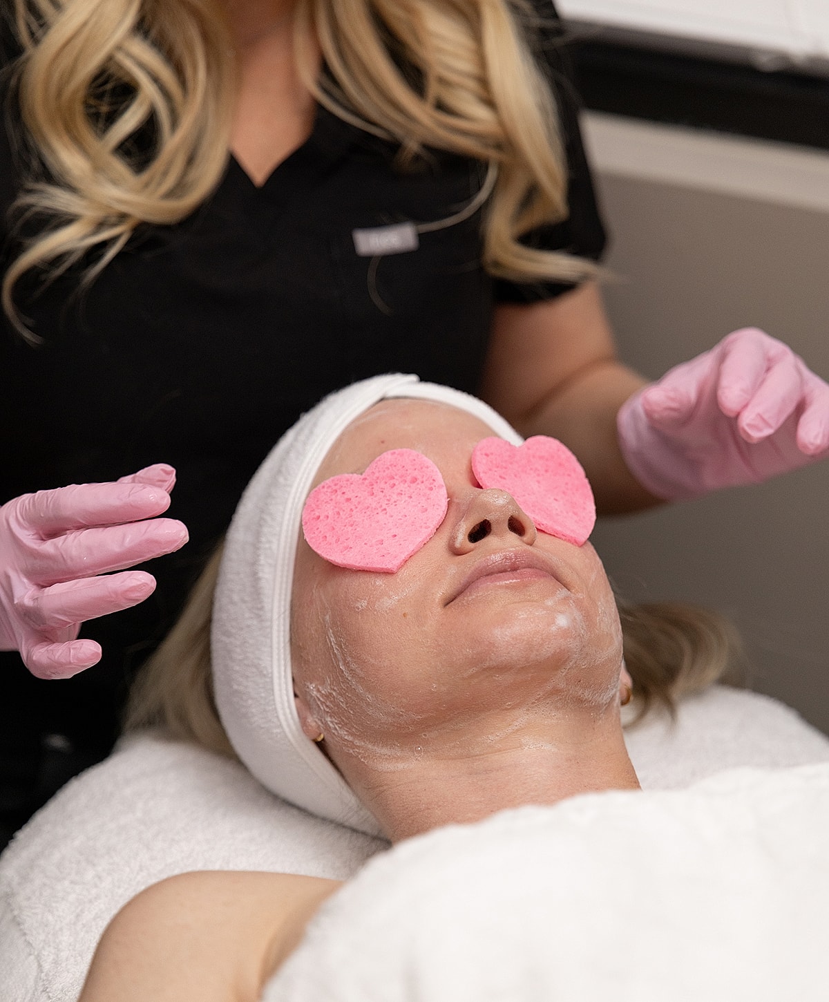 Facial treatment with heart-shaped sponges.