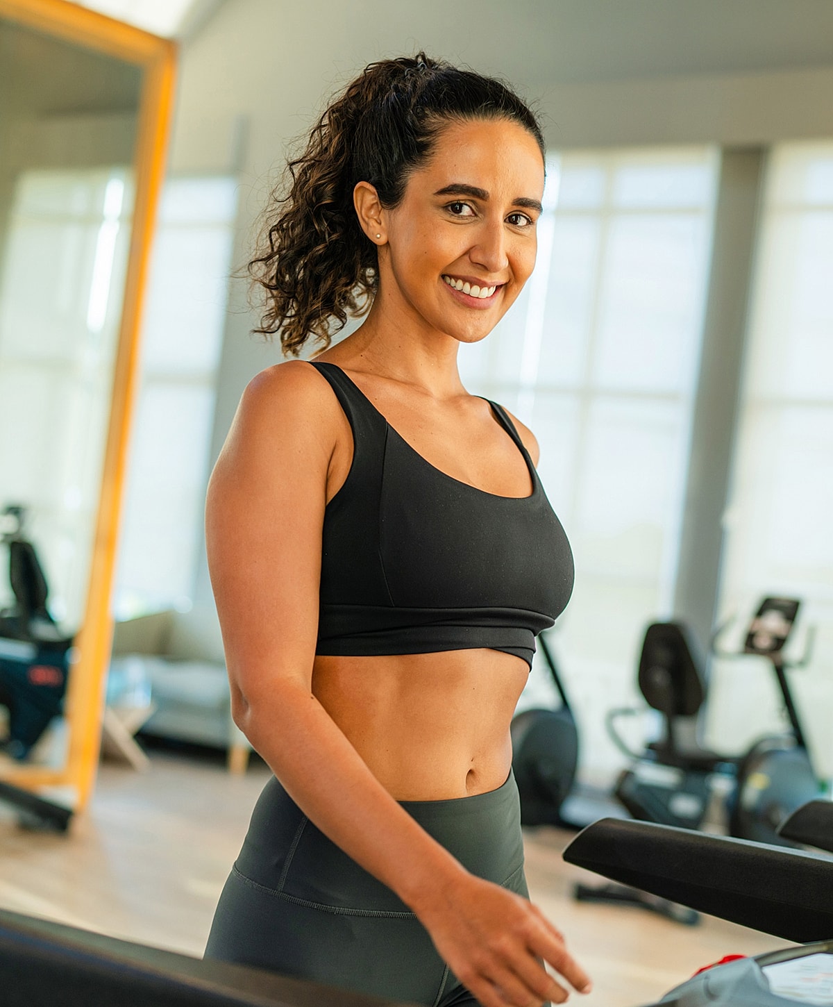Smiling woman at gym in activewear.