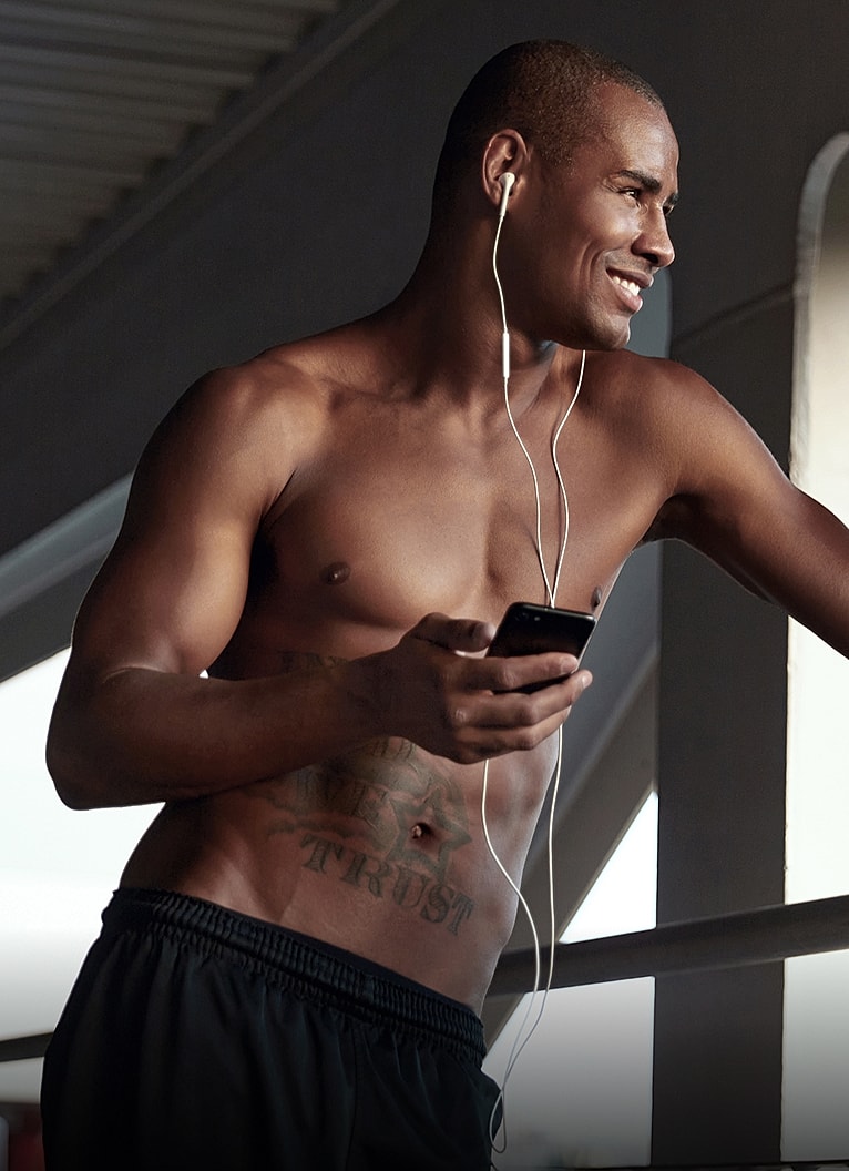 Man with earphones using a smartphone outdoors.